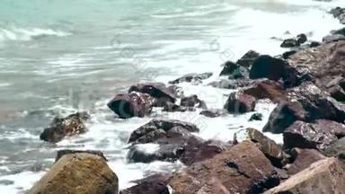 夏日里，海浪拍打着岩石海滩. 关闭海浪溅在海洋海滩上。 美丽的海浪